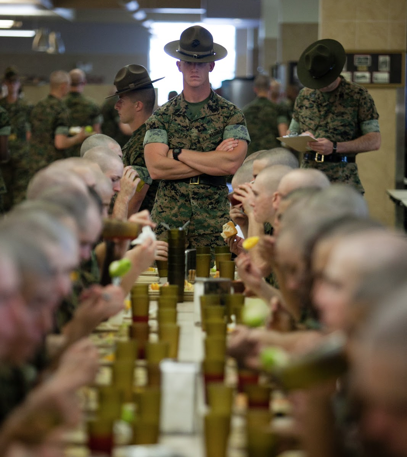 Recruits eating lunch under the watchful (and strict) eye of their drill instructor.